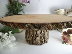 a table made out of wood with flowers in the background