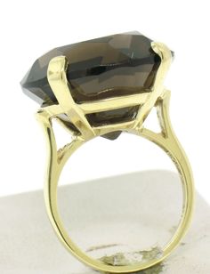 A HUGE round smokey topaz sits in the center of a simple polished 4 prong solid 14k yellow gold mounting. A simple solitaire ring that will surely make a statement due to its massive size. Enjoy! Material: 14k Solid Yellow Gold Weight: 9.7 Grams Stone: (1) Natural Genuine Topaz - Round Brilliant Cut - Prong Set - Deep Smoky Brown Color - 20.20mm Diameter x 13.0mm Deep - 33.90ct (approx.) Diameter: 20.20mm Height: 13mm (rises off the finger) Size: 6.50 (We can also custom size this ring.) Conditi Classic Smoky Quartz Rings For Formal Occasions, Classic Smoky Quartz Jewelry For Formal Occasions, Classic Formal Smoky Quartz Rings, Faceted Topaz Ring For Formal Occasions, Formal Faceted Topaz Round Ring, Formal Faceted Topaz Ring, Elegant Smoky Quartz Jewelry For Formal Occasions, Elegant Gold Topaz Ring With Round Stone, Classic Round Faceted Topaz Ring