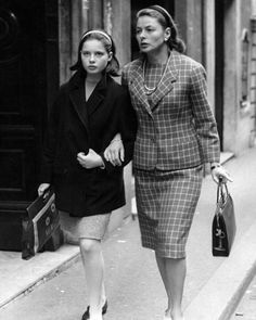 two women are walking down the street together