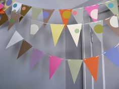 there are many flags hanging on the wall in this room, one is multicolored