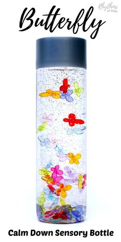 a water bottle filled with lots of colorful gummy bears on top of a white surface