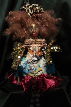 a doll with red hair and leopard print on it's head, sitting in front of a black background