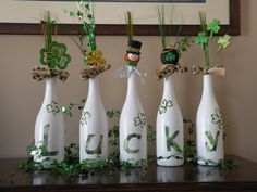 four st patrick's day wine bottles with shamrock decorations