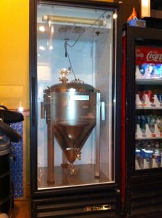 a beverage dispenser sitting inside of a glass case