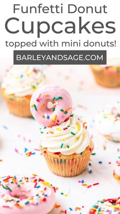 cupcakes topped with pink frosting and sprinkles on a table