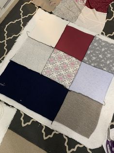 several pieces of fabric laid out on a rug