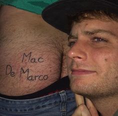 a man with a tattoo on his stomach that reads mac de marco in spanish