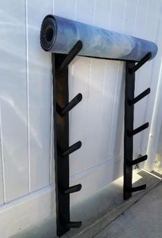 a metal rack with two black bars on it next to a white wall and door