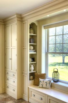 a window seat in the corner of a room with built - in bookshelves