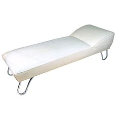 a white leather chaise lounger with metal legs on an isolated white background, viewed from the front