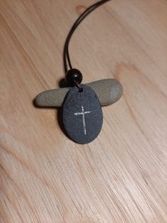 Hand carved Christian Cross on stone necklace with silver enamel inlay. Leather cord is 1m long, 1.5mm thick and tied into a sliding knot necklace. Pendant is attached to the cord by a copper plated hoop. Includes a black velvet pouch. Pieces are unique and may slightly differ in colour and size, as is the nature with hand carved natural stones :) Thanks! Adjustable Cross Pendant Jewelry, Adjustable Etched Symbolic Necklace, Adjustable Symbolic Etched Necklace, Symbolic Adjustable Etched Necklace, Spiritual Necklace With Sliding Knot As Gift, Spiritual Necklace With Sliding Knot For Gift, Spiritual Cross Jewelry With Adjustable Cord, Adjustable Round Pendant Waxed Cord Jewelry, Symbolic Adjustable Etched Necklaces