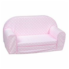 a pink couch with white polka dots on the back and arms, sitting against a white background