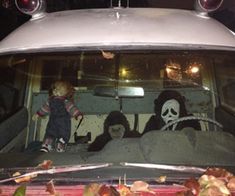 two stuffed animals are sitting in the back of a car with skulls and bones on it