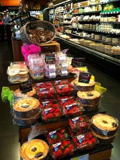 a display in a grocery store filled with lots of different types of pies and pastries