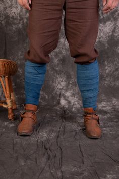 a man in brown pants and blue socks standing next to a stool