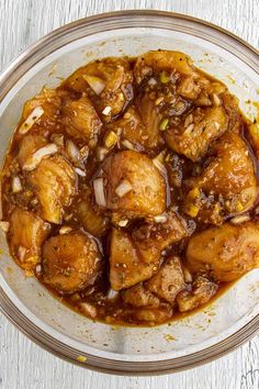 a bowl filled with meat and sauce on top of a table