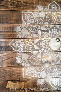 an old wooden wall painted with white paint and decorative designs on the wood planks