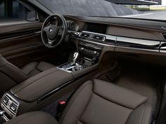 the interior of a modern car with leather trims and steering wheel, center console