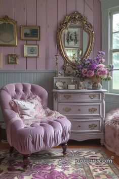 a pink chair sitting in front of a dresser with flowers on it and a mirror