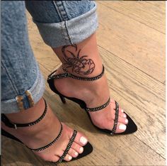 a woman's foot with a tattoo on her left ankle and the bottom part of her leg