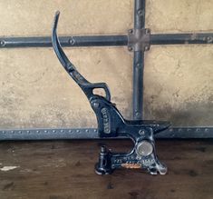 an old sewing machine sitting on top of a wooden table next to a metal bar