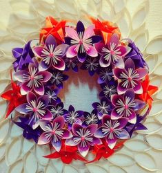 a paper flower wreath is displayed on a table