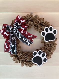 a dog's paw and bone print wreath on a wooden door with burlocks