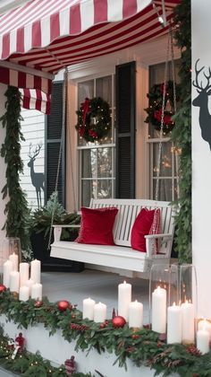 a porch decorated for christmas with candles and wreaths