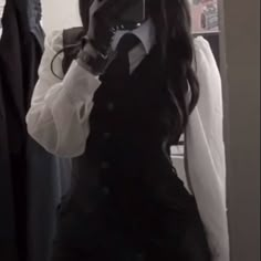 a woman taking a selfie in front of a mirror wearing a black and white outfit