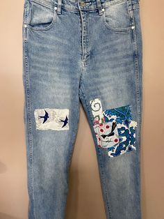 a pair of blue jeans with patches on them