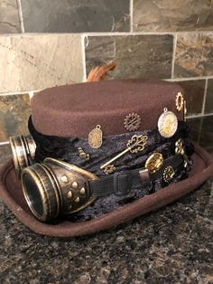 Steampunk men's top hat. Bronze clocks and accessories. Felt brown too hat. Real bird soft feathers. Crushed velvet band. Bronze goggles. Great for an old vintage look. Or Halloween. Or a great party look. Steam Punk Top Hat, Steam Punk Fashion Mens, Steampunk Brown Hat For Halloween, Winter Festival Vintage Mini Hats, Brown Steampunk Party Hat, Vintage Brown Hat For Halloween, Adjustable Brown Top Hat For Costume, Brown Adjustable Top Hat For Costume, Steampunk Adjustable Hat For Costume