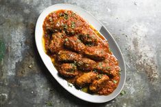 a white plate topped with meat covered in sauce