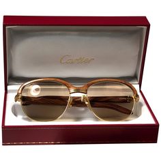 Original 1990 Cartier Malmaison hardwood banana light wood sunglasses with honey brown Cartier (uv protection) lenses. Front and sides in yellow and white gold and has the famous wooden front. Temples are also Palisander combined with gold. Amazing craftsmanship! All hallmarks. Both arms sport the C from Cartier on the temples. These are like a pair of jewels on your nose with the 18k gold frame and white gold accents. Beautiful design and a real sign of the times This Item has minor sign of wea Luxury Cartier Sunglasses With Tinted Lenses, Modern Gold Cartier Sunglasses, Cartier Gold Tinted Sunglasses, Cartier Gold Sunglasses With Tinted Lenses, Luxury Gold Cartier Sunglasses, Gold Cartier Sunglasses With Gradient Lenses, Cartier Gold Sunglasses With Gradient Lenses, Classic Cartier Sunglasses With Gradient Lenses, Classic Cartier Tinted Sunglasses