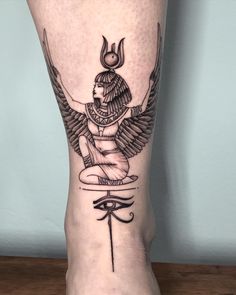 an egyptian tattoo on the leg of a woman's foot, with wings and eye