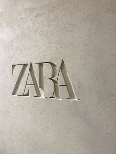 the word zara is carved into the side of a white wall with letters on it