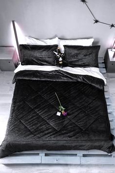 a black bed with white sheets and pillows