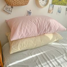 three pillows stacked on top of each other in front of a wall with pictures and clocks