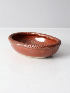 a brown bowl sitting on top of a white table