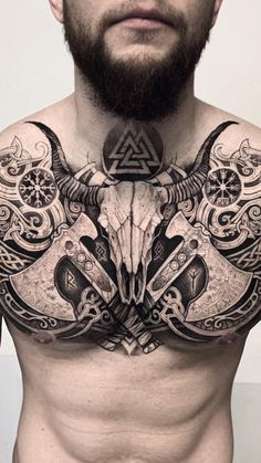 a man with tattoos on his chest has an animal head in the middle of his chest