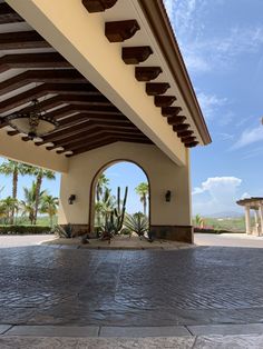 the entrance to a building with arches and cactus trees in the backgrouds