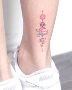 a woman's foot with a small tattoo on the side of her leg, which is decorated with stars and planets