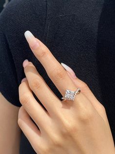 a woman's hand with a diamond ring on it