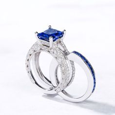 This eye-catching interchangeable ring set features an enchanting radiant cut stone and rows of smaller stones embellish the engagement ring in profile. Milgrain detailing along the ring's shank adds depth and dimension to this elegant design. Additional stones are set into the matching band. Gleaming with your love, this slender wedding set is a true reminder of your everlasting love.Carat Weight: 5.2 ctStone Size: 8*10 mmStone Type: Jeulia® StoneNumber of Stones: 1 Stone Color: Sapphire BlueStone Shape: RadiantCarat Weight: 3.24 ctStone Size: 1.5*1.5,2,1.75,1.5,1.25,1.2 mmStone Type: Jeulia® StoneNumber of Stones: 130 Stone Color: Sapphire Blue, Diamond WhiteStone Shape: Princess, RoundWeight: 7.26 gWidth: 10.55 mmHeight: 8.65 mmThickness: 7.6 mmMaterial: 925 SilverPlating Color: Silver Square Cut Wedding Diamond Ring With Accent Stones, Blue Radiant Cut Cubic Zirconia Rings, Blue Sapphire Ring Radiant Cut For Wedding, Wedding Sapphire Ring With Diamond Side Stones, Sapphire Radiant Cut Ring With Accent Stones, Sapphire Ring With Radiant Cut And Accent Stones, Sapphire Cubic Zirconia Jewelry In Radiant Cut, Sapphire Radiant Cut Cubic Zirconia Jewelry, Sapphire Wedding Ring, Radiant Cut