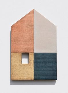 a house made out of wood with different colors on the front and back side,