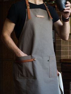 a man in an apron holding a cup