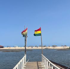 two flags are on the end of a pier