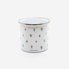 a white and gold canister with cactus print on the side, in front of a white background