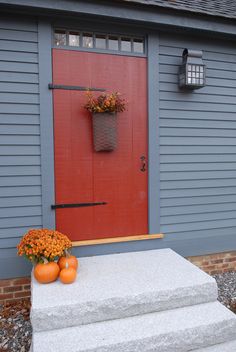 a red front door with two planters on it