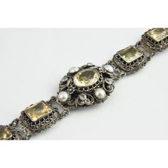 Austro-Hungarian citrine bracelet created between 1860 and 1910. Features an oval citrine surrounded by an ornate silver frame with pearl and paste accents. The main section has a band with 6 citrines mounted in silver frames. The metal is 800 silver.  Please see the measurements noted above in the description for best approximate dimensions Vintage Rose Cut Diamond Bracelet, Victorian Hallmarked Citrine Jewelry, Antique Silver Citrine Jewelry, Citrine Bracelet, Austro Hungarian, Silver Frames, Silver Frame, Citrine, Silver Bracelet