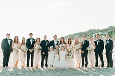 a group of people standing next to each other on a beach